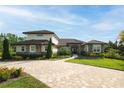 Beautiful home featuring stone accents, a tile roof, a paver driveway, and meticulously maintained landscaping at 17305 Ballmont Park Dr, Odessa, FL 33556