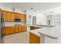 Spacious kitchen featuring modern appliances, wooden cabinetry, and sleek white countertops at 17812 Arbor Greene Dr, Tampa, FL 33647