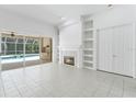 Bright living room featuring tile floors, a fireplace, and seamless access to the outdoor pool area at 17812 Arbor Greene Dr, Tampa, FL 33647