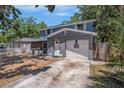 Two-story home with blue siding, a covered porch, and a one-car garage at 3115 W Wyoming Ave, Tampa, FL 33611