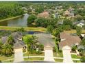 Aerial view of homes with a pond and mature trees showcasing the tranquil and well-planned community at 3254 Grassglen Pl, Wesley Chapel, FL 33544