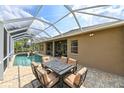 Covered patio with comfortable seating and table, and an inviting pool for outdoor living at 3254 Grassglen Pl, Wesley Chapel, FL 33544