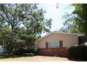 Home exterior showcasing brick accents and a well-maintained lawn with mature trees at 3306 Lacewood Rd, Tampa, FL 33618