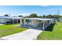 Inviting single-story home with covered parking, showcasing curb appeal, lawn, and welcoming front entrance at 36848 Beth Ave, Zephyrhills, FL 33542
