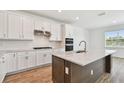 The gourmet kitchen showcases a stylish island, sleek appliances, and elegant white cabinetry at 37194 Clinch Cir, Zephyrhills, FL 33540
