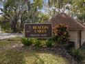 Community sign for Beacon Lakes Private Way surrounded by lush greenery and mature trees at 4016 Lighthouse Way, New Port Richey, FL 34652