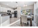Well-lit kitchen with white cabinets, black appliances, and an adjacent dining area at 4550 Globe Thistle Dr, Tampa, FL 33619
