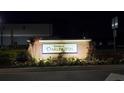 Illuminated brick sign for Townes at Darlington surrounded by colorful flowers and greenery at night at 5131 Forum Blvd, Holiday, FL 34690