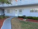 Condo building entrance with well-kept landscaping featuring flowers, mulch, and stepping stones leading to the unit at 5660 80Th N St # A102, St Petersburg, FL 33709
