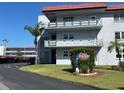 Three story condo building with carports, signage, and well-manicured green spaces in a tropical locale at 5660 80Th N St # A102, St Petersburg, FL 33709