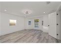 Bright bedroom featuring wood-look flooring, natural light, and a modern ceiling fan at 6136 56Th N Ave, St Petersburg, FL 33709
