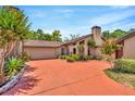 Inviting single-Gathering home with a 2-car garage, chimney, mature landscaping, and a red brick driveway at 713 Dorado Ct, Brandon, FL 33511