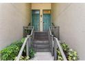 Inviting condominium entrance with dual teal doors, stone steps, and well-maintained landscaping at 728 Seagate Dr, Tampa, FL 33602