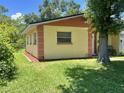 Side view of single-Gathering home featuring a well-maintained lawn and mature trees at 772 71St N Ave, St Petersburg, FL 33702
