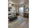 Bright living room with wood floors, comfortable seating, and large window, offering a welcoming and relaxing space at 9117 41St N Way # 5, Pinellas Park, FL 33782