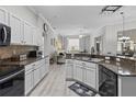 Stylish kitchen with stainless steel appliances, granite counters, white cabinetry and open view to living area at 9723 Rolling Cir, San Antonio, FL 33576