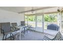 Relaxing screened patio with neutral colored patio furniture and plenty of shade at 10016 Glen Moor Ln, Port Richey, FL 34668