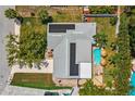 Aerial view of home, showcasing the pool, solar panels, and landscaped yard at 10448 Hetrick W Cir, Largo, FL 33774