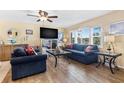 Cozy living room featuring shuttered windows, wood-look flooring, and comfortable seating at 10448 Hetrick W Cir, Largo, FL 33774