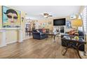Bright living room with wood-look flooring, comfortable seating, and open layout at 10448 Hetrick W Cir, Largo, FL 33774