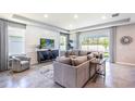 Cozy living room with gray walls, a large sectional sofa, and a decorative rug at 10645 Bridgegate Heights Loop, San Antonio, FL 33576