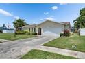 Exterior view of a one-story home with a two-car garage and well-maintained front lawn at 12933 90Th Ave, Seminole, FL 33776