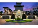 Elegant home featuring a barrel tile roof, manicured landscaping, circular driveway, and a grand entrance at 1600 Magnolia Rd, Belleair, FL 33756