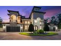 A luxurious home featuring a tower entry, arched windows, a balcony, multi-car garage, and an inviting driveway at 1600 Magnolia Rd, Belleair, FL 33756