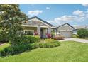 Charming exterior view with stone accents, lush landscaping, and well-maintained front yard at 1741 Cherry Walk Rd, Lutz, FL 33558
