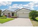 Attractive exterior with brick driveway, lush green lawn, and well-manicured landscaping at 1741 Cherry Walk Rd, Lutz, FL 33558