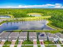 An aerial view of a neighborhood featuring a beautiful lake and lush greenery at 17683 Ramble On Way, Land O Lakes, FL 34638