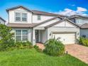 Charming two-story home with well-maintained landscaping and a brick paver driveway at 17683 Ramble On Way, Land O Lakes, FL 34638