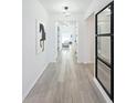 Hallway featuring stylish floors, modern lighting, with views to a living area at 17683 Ramble On Way, Land O Lakes, FL 34638