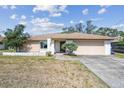 Charming single-story home with a large concrete driveway and an attached garage at 2071 Linwood Ave, Spring Hill, FL 34608