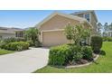 Exterior shot of a beige two-story home featuring a well-kept lawn, mature landscaping and an attached two car garage at 2803 130Th E Ave, Parrish, FL 34219