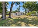 Side view of home with spacious yard and mature trees, offering a serene setting at 3622 Tamarix Dr, Tampa, FL 33619