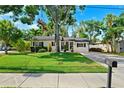 The home has beautiful curb appeal with a lush lawn and mature trees at 3914 W Cleveland St, Tampa, FL 33609