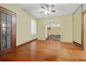 Open living room with hardwood floors, ceiling fan, windows and entryway featuring a tiled hallway at 4100 1St S Ave, St Petersburg, FL 33711