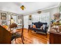 Cozy living room featuring hardwood floors, vintage furniture, and natural light streaming through plantation shutters at 4124 W San Juan St, Tampa, FL 33629