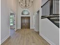 Grand foyer showcasing wood-look floors, a statement chandelier, and staircase with an iron railing at 4224 W Corona St, Tampa, FL 33629
