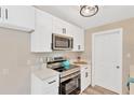 Modern kitchen with stainless steel microwave, stove, white cabinets and white countertop at 4304 W Arch St, Tampa, FL 33607