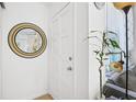 Bright entryway featuring a white door, round mirror, and decorative plant at 4306 La Mora Ct, Tampa, FL 33611