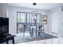 Cozy dining area with a glass table, modern chairs, and natural light from the sliding glass doors at 5970 80Th Street North # 206, St Petersburg, FL 33709