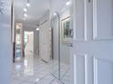 Bright entryway featuring white tile floors, an arched mirror, and a view into the dining area at 5970 80Th Street North # 206, St Petersburg, FL 33709