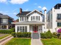 Charming two-story home featuring a welcoming front porch, and well-manicured lawn at 723 S Brevard Ave, Tampa, FL 33606