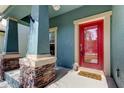 Inviting front porch featuring stone accents on the pillars and a bright red front door with glass panel at 7513 S Sparkman St, Tampa, FL 33616