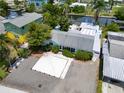 Aerial view of a quaint blue home with water access and mature tropical landscaping at 832 Seabreeze Dr, Ruskin, FL 33570