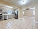Bright kitchen featuring modern appliances, mosaic backsplash, tile floors, and easy access to other rooms at 8345 81St Ct, Seminole, FL 33777