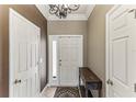 Inviting foyer with tile floors, a decorative table, and white doors, leading to the rest of the home at 8518 Broken Willow Ct, Tampa, FL 33647