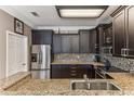 Spacious kitchen featuring stainless steel refrigerator, dark wood cabinets, and granite countertops at 8518 Broken Willow Ct, Tampa, FL 33647